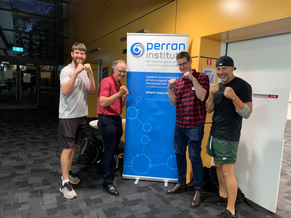 FIGHT-PD team Mitchell David Travis and Rai in front of Perron Institute banner
